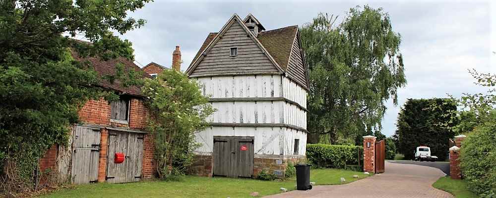 A dovecote surrounded by houses and trees